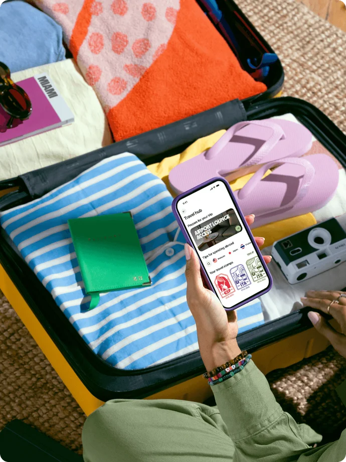 Person using Wise app to explore airport lounges whilst packing suitcase