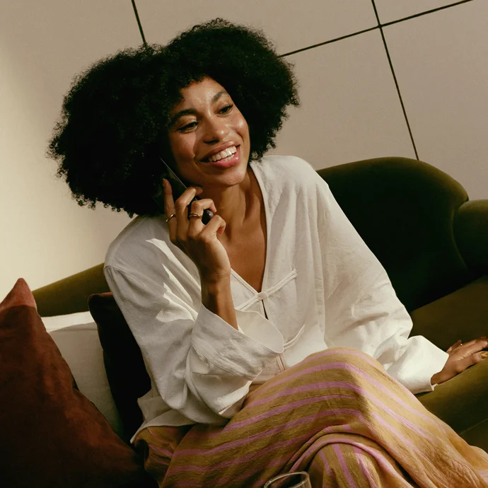 Smiling woman making a call on a mobile phone, showing Wise's support for large money transfers.