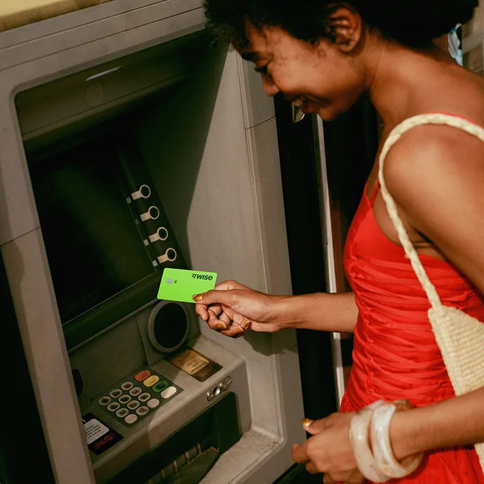 Person inserting Wise card into an ATM machine for an international withdrawal.