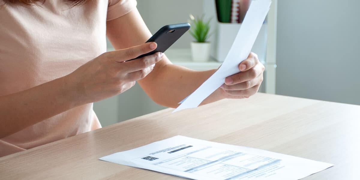 Eine Frau scannt eine rechnung mit dem Smartphone