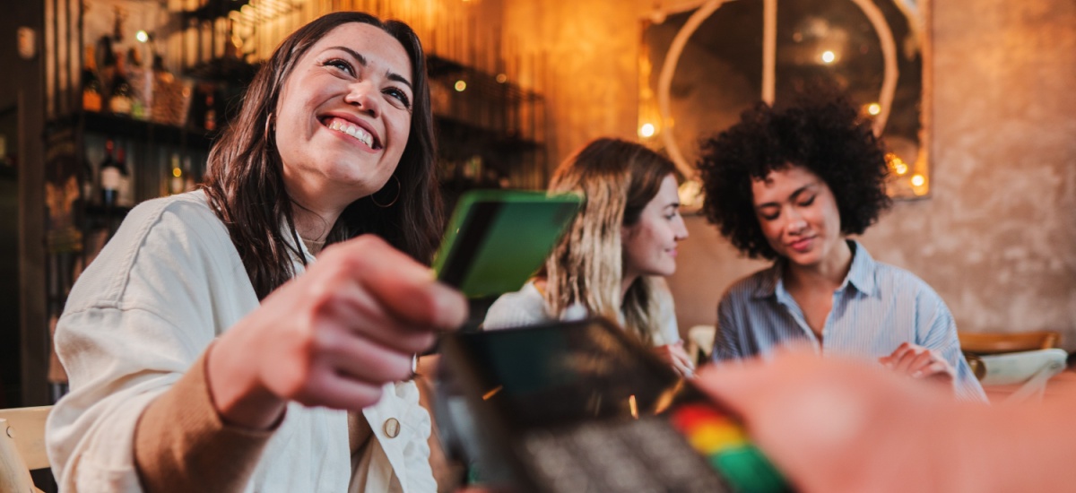 happy-woman-paying-by-card-at-restaurant