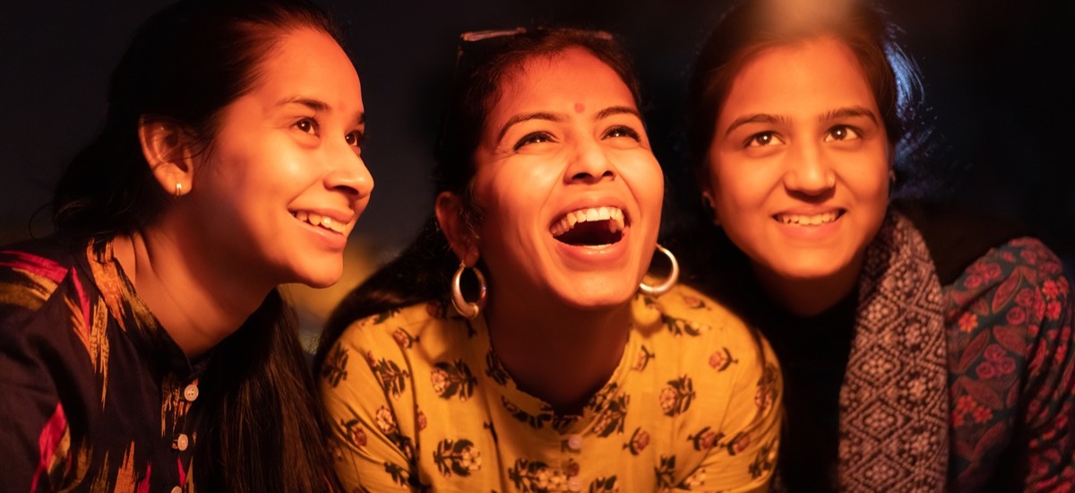 three women celebrating Diwali looking up into the sky
