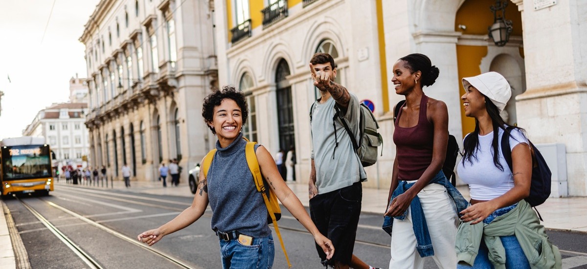 group of friends in Lisbon crossing street with tram