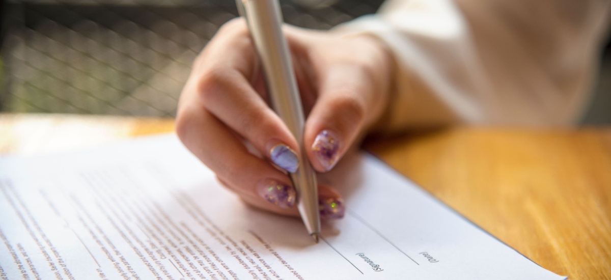 woman-signing-documents-with-a-pen