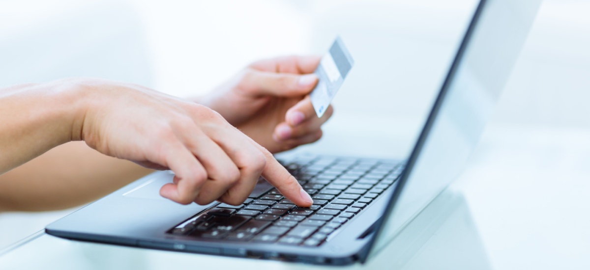 hands-typing-on-laptop-holding-bank-card