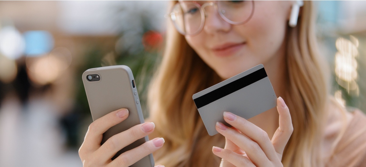 closeup-of-young-woman-holding-debit-card-and-phone