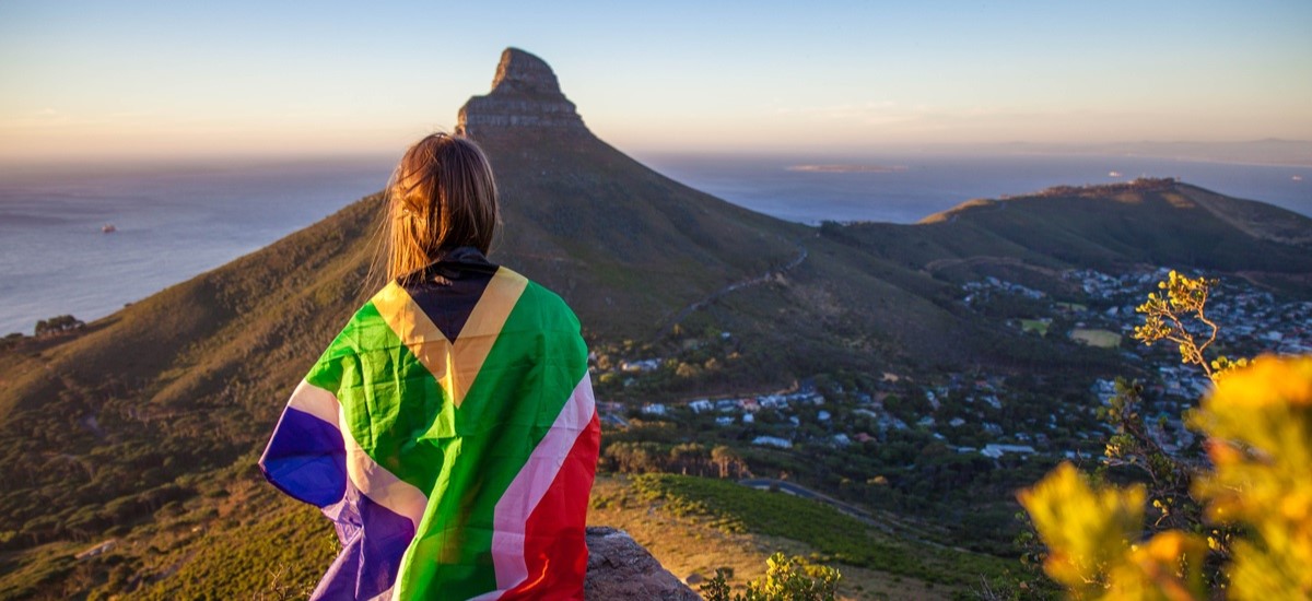 Woman wearing South African flag on top of a mountain