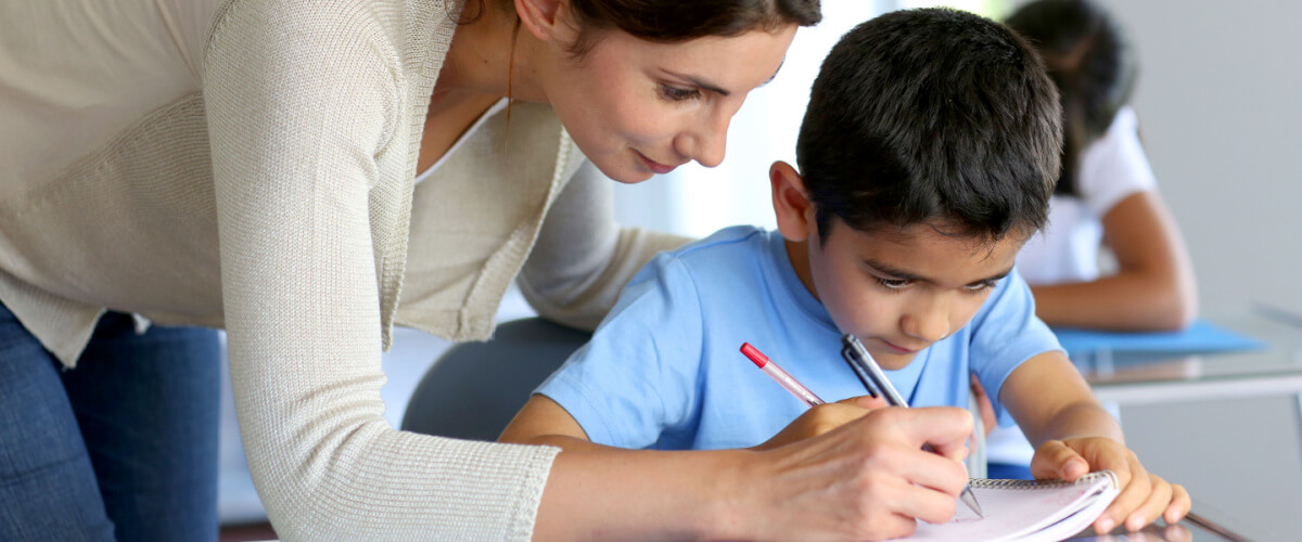 teacher-helping-student-write