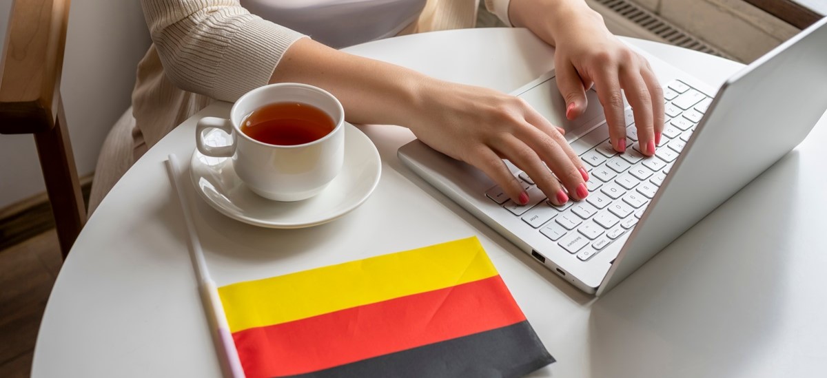 Close up of a laptop on a table next to a German flag
