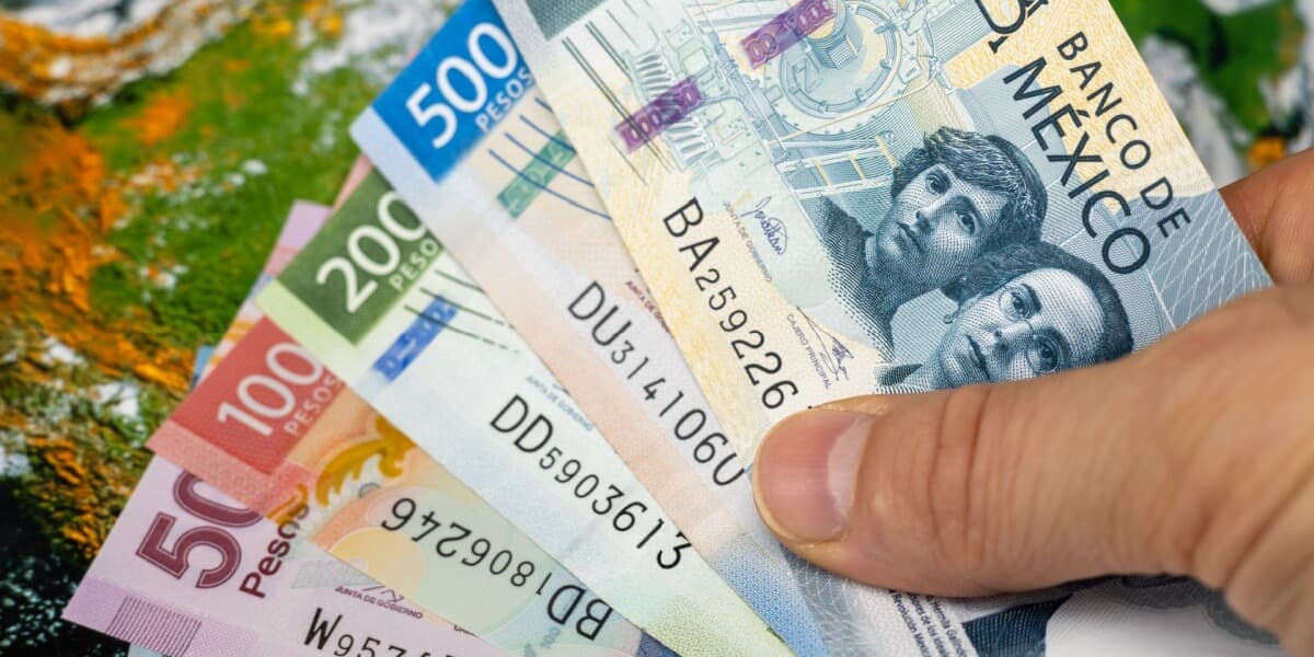 Eine Hand hält mehrere mexikanische Banknoten