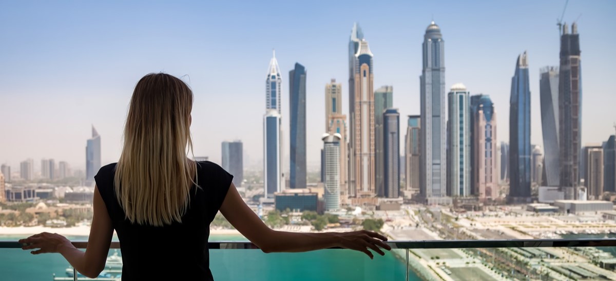 woman on a balcony looking out onto Dubai skyline