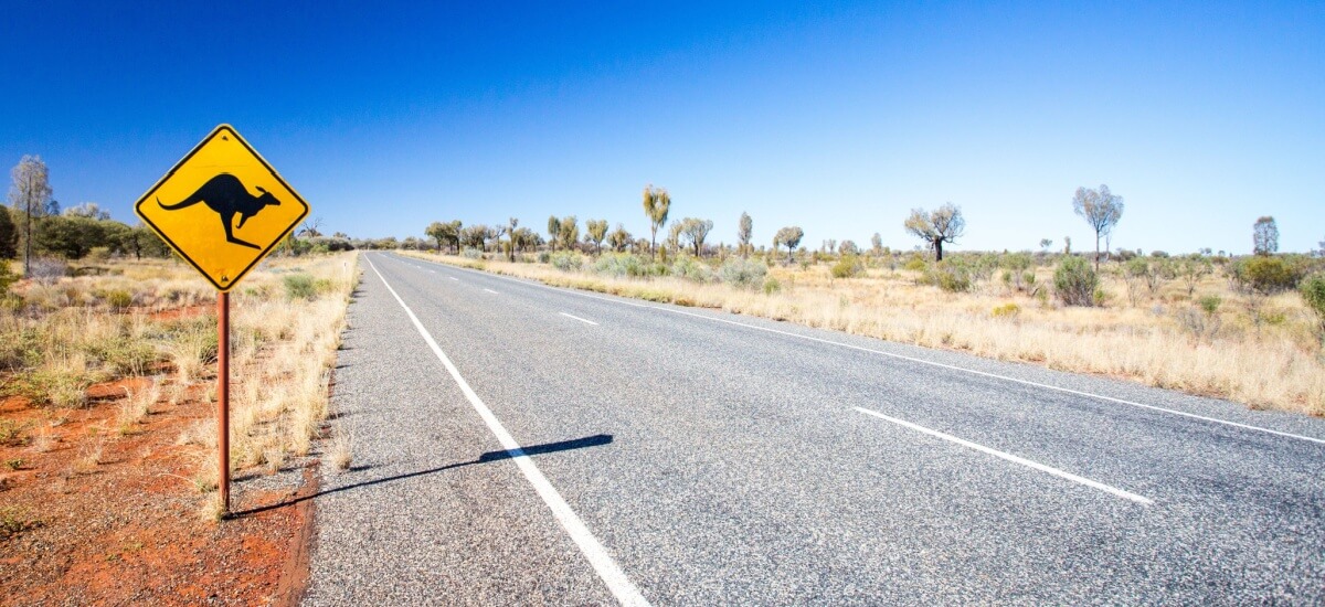 Strasse im australischen Outback mit Känguru-Strassenschild