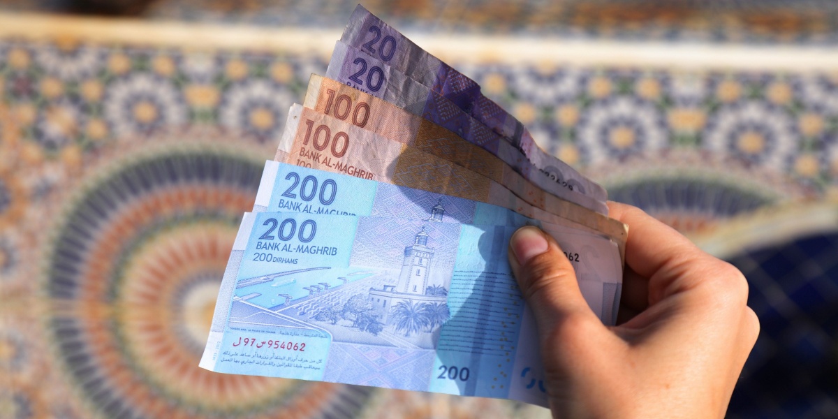 Eine Hand hält mehrere marokkanische Geldscheine
