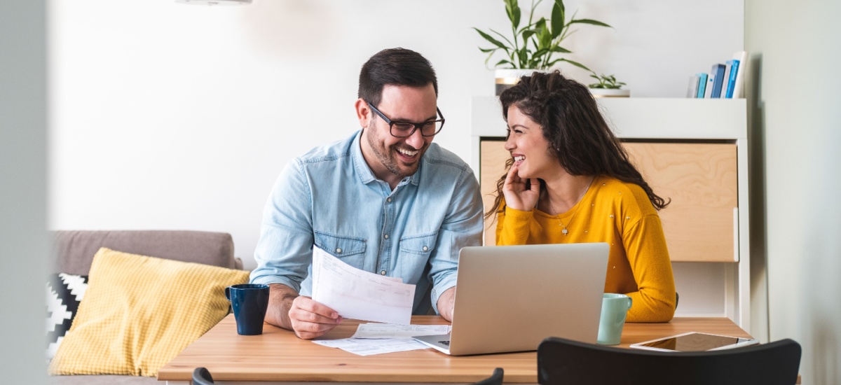 Couple smiling signing documents