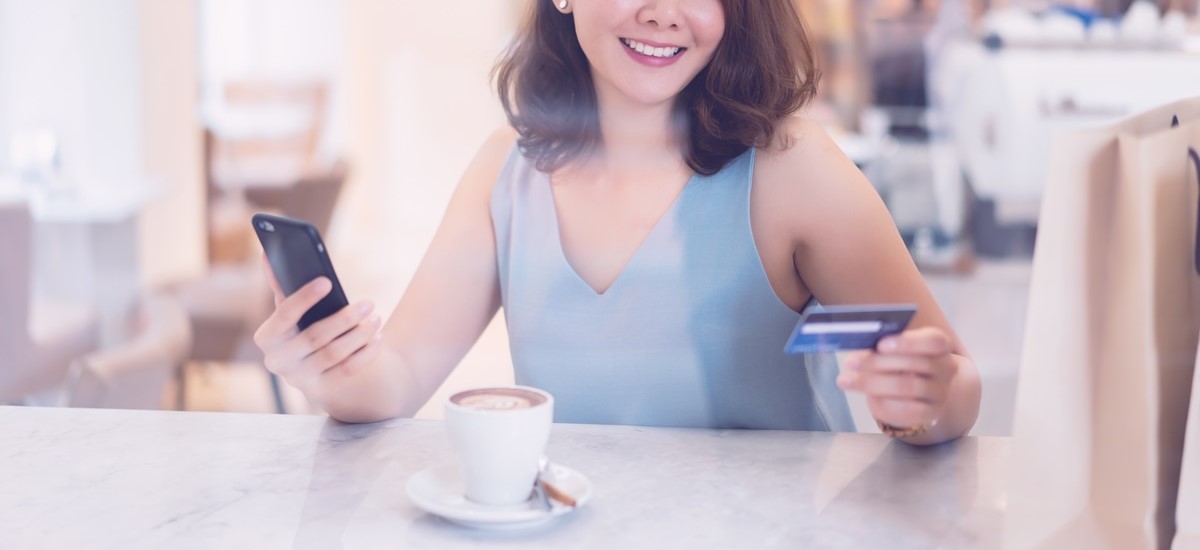 一个女人正在用银行卡为一杯咖啡付钱