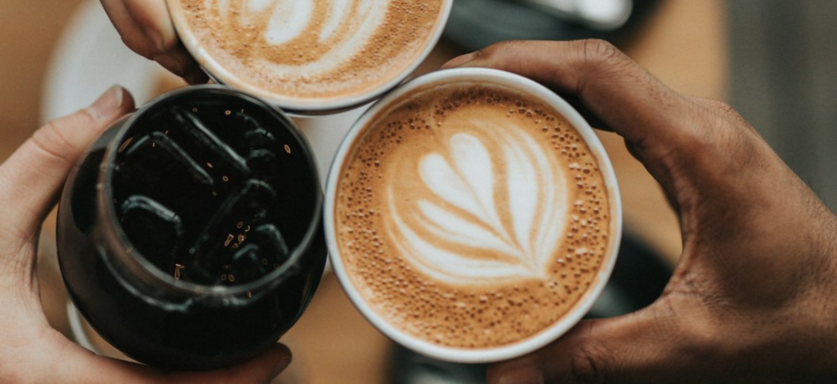 Close up of three different coffee types, two with latte art and one iced