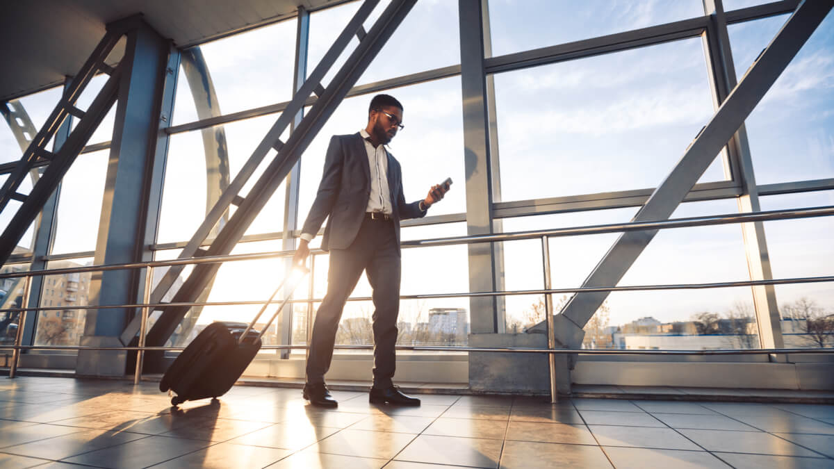 men-walking-on-airport-holding-luggage