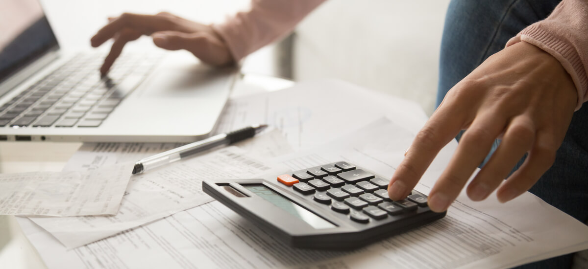 woman-using-calculator-and-laptop