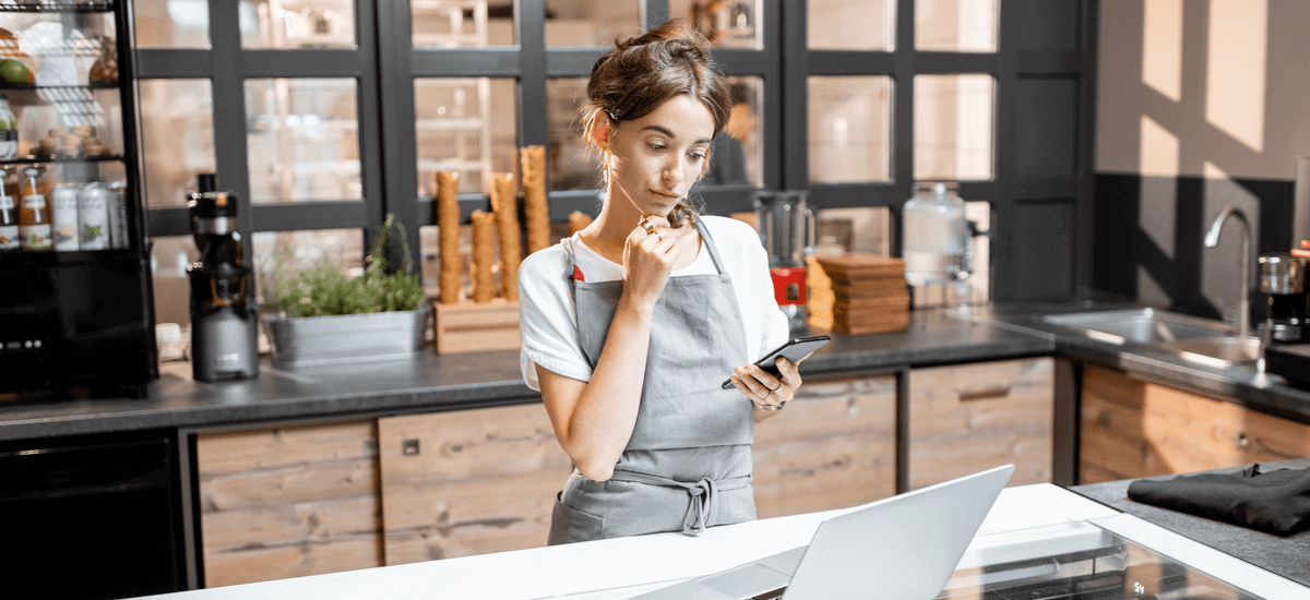 saleswoman-working-in-shop-with-laptop